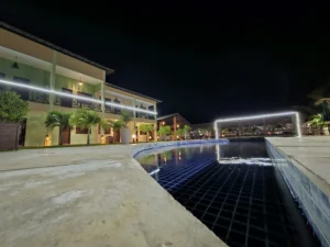 Vista noturna da área da piscina e instalações da Pousada Bellissima Italia na Praia de Barro Preto.